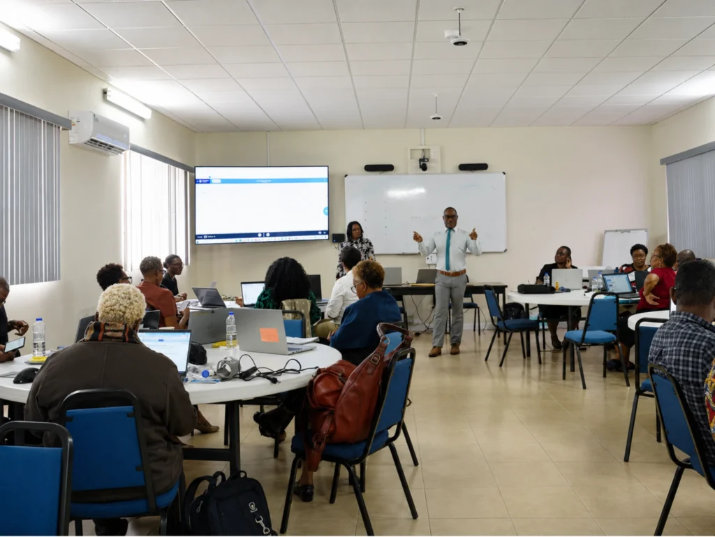 Trainer leading a digital skills class with learners at laptops